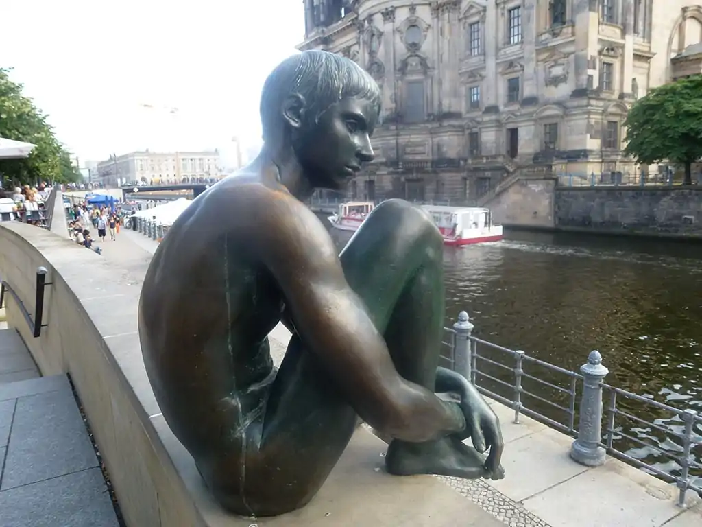 Statua su riva del fiume che guarda nel vuoto, foto che simboleggia uno stato della depressione